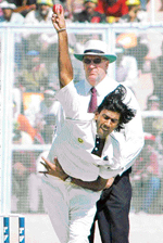 Laxmipathy Balaji bowls to Pakistan batsman Taufeeq Umar as umpire Darrell Hair looks on during the fourth days play of the first Test in Mohali on Friday.