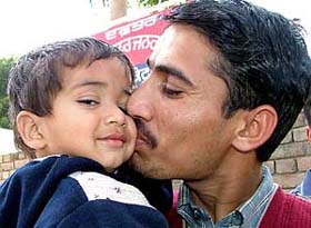 Sanjeev Kumar holds his son after he was rescued from abductors
