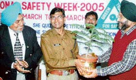 Mr NS Virdi, assistant general manager, Siel Chemical Complex, Rajpura, presents a plant to Mr Kastumbh Shrama, SP (Traffic), Patiala, on the closing of ‘National Safety Week-2005’ in Rajpura
