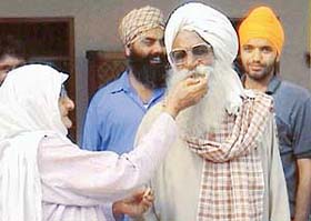 Ajaib Singh Bagris mother offers sweets to her husband, after her son was acquitted by a Canadian court, in Chak Kalan village in Jalandhar district