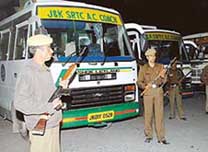Policemen keep a strict vigil in front of the special buses in Srinagar on Saturday that will carry the passengers to Muzaffarabad on April 7.