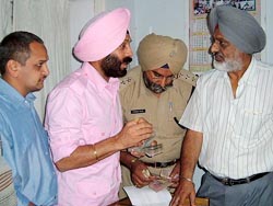All India Anti-Terrorist Front chief M.S. Bitta questions the District Sainik Welfare Officer, Lt-Col S.P. Singh (retired), while the DSP holds the money recovered from him. The martyrs brother Vijay Ahuja is also seen in the picture. 