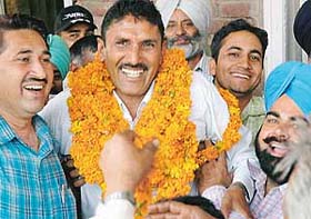 Mr Sita Ram (in garlands) is all smiles after getting elected as chairman of the market committee in Sector 17, Chandigarh