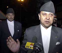 Nepals King Gyanendra is watched by his son Crown Prince Paras as he addresses media representatives at Tribhuvan International Airport in Kathmandu on Saturday night. 