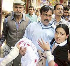 An injured girl being rushed for medical aid after a grenade explosion outside the gate of a school on Residency Road of Srinagar on Thursday.