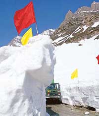 An Army truck passes through walls of snow after the Srinagar-Leh road was opened to traffic in Zojila, 108 km east of Srinagar, on Friday. 