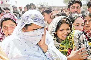 Relatives of blast victims mourn at the scene of the incident at the Bari Imam shrine in Islamabad on Friday.