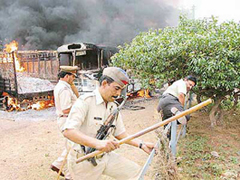 Policemen and others run for cover as buses and vehicles are set ablaze outside the Dadri railway station in UP on Friday