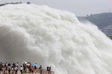 People gather on a platform to watch as water from the Xiaolangdi Reservoir is released into the Yellow River