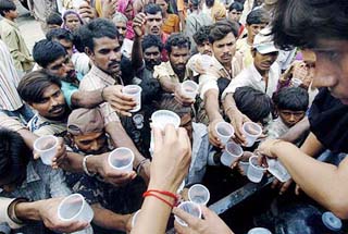 Volunteers distribute food and drinking water to flood victims on a national highway near the village of Kheda, 45 km south-west of Ahmedabad, on Sunday.