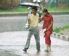 A young couple looks for shelter following heavy showers in the city on Monday afternoon