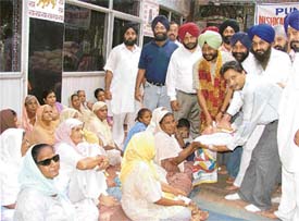 Members of Nishkam Sewa Mission distribute ration among needy women at a function in Ludhiana