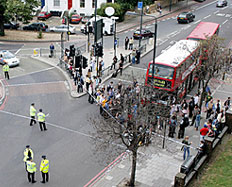 Police officers and people stand around a cordon outside Stockwell underground train station after a man was shot dead in south London on Friday.