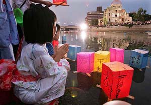 A Japanese child in "yukata" offers prayers as she floats paper lanterns for atomic bomb victims, along the city's Motoyasu River, near ground zero, Hiroshima, on Saturday.