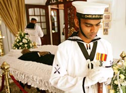 Soldiers stand with their heads bowed around the body of Sri Lankas slain Foreign Minister Lakshman Kadirgamar at his official residence in Colombo on Saturday.