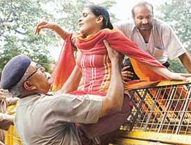 A police officer helps a visually challenged woman to cross the barricade as she joins protesters during a demonstration in New Delhi on Tuesday.