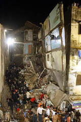 Firemen and rescue workers look for survivors in the debris of a residential building that collapsed in Mumbai