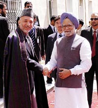 Prime Minister Manmohan Singh shakes hands with Afghan President Hamid Karzai during their meeting at President Palace at Kabul on Sunday
