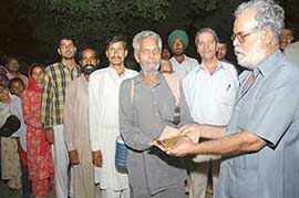 Jagdish Lal Ahuja (right) distributes food among needy patients and their relatives at the PGI, Chandigarh.