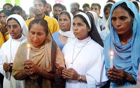 Dalbir Kaur, sister, and Sukhpreet Kaur, wife, of Sarabjit Singh join members of the Christian community at a candlelight vigil at Jai Rani Church, Fatehgarh Churian, near Amritsar, on Sunday for his release