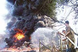 Firemen attempt to extinguish a blaze at an oil well in Dikom, about 520 km east of Guwahati