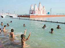 Children take a holy dip at Brahm Sarovar on the eve of solar eclipse at Kurukshetra on Sunday
