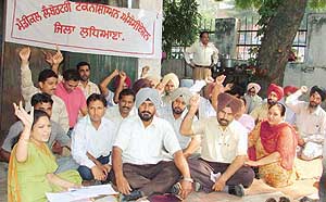 Laboratory technicians of the Health Department stage dharna in support of their demands in Ludhiana on Monday.