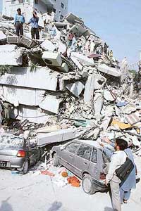 Cars are crushed under the rubble of a partly collapsed 19-storey housing complex after a severe earthquake in Islamabad on Saturday
