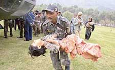 A soldier carries an injured child in Badami Bagh cantonment in Srinagar after a severe earthquake on Saturday