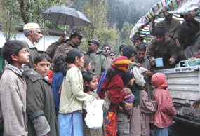 Children stand in a long line at a relief camp at Jabla, about 110 km north of Srinagar, on Monday.