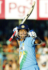 M. S. Dhoni waves his bat after hitting the winning shot against Sri Lanka during their third one-day international in Jaipur on Monday.