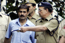 Mohammad Arif is escorted by policemen as he walks out after being sentenced to death by a special court in Delhi on Monday.