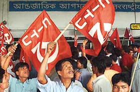 CPM activists wave flags as they stage a demonstration outside Netaji Subhas Chandra Bose International Airport in Kolkata on Friday after the arrival of a US Air Force aeroplane
