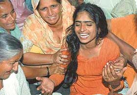 Inconsolable Rajwinder Kaur, mother of two children who were crushed to death in a train-school van accident at Uppal Khalsa village near Noormahal