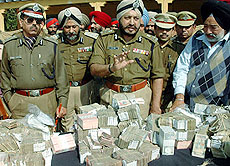 DGP S.S. Virk shows money recovered from Uco Bank robbers at Police Lines in Jalandhar on Saturday.