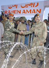 Pakistans Army officer, Lieut-Col Salman Ahmed, shakes hands with his Indian counterpart, Col Gurwinder Singh, prior to the opening of the fourth crossing point for aid supplies on the Line of Control at the Mendhar Nala sector in Tatta Pani on Monday