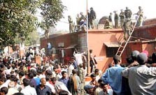 Local residents gather around Jehanabad district jail on Monday morning after Naxalites mounted a fierce attack on the jail on Sunday night