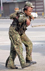 A paramilitary jawan carries his injured colleague following a suicide attack in Srinagar on Monday