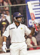 Yuvraj Singh raises his bat after completing his half century