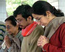 Saurabh Puri, son of the slain IIT professor M.C. Puri, flanked by Raksha Puri and sister Shelly, pays last tributes to his father before the cremation in New Delhi on Friday.