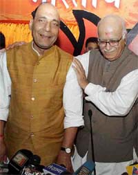 Outgoing BJP President L K. Advani greets his successor Rajnath Singh at a press conference in Mumbai