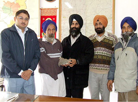 An NRI hands over Rs 50,000 to the father of schizophrenic sisters in Bathinda on Monday. Mr Rahul Bhandari, Deputy Commissioner (left), is also seen in the picture.