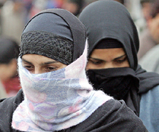 Kashmiri women, with their faces covered to protect themselves from the cold, walk on a street in Srinagar on Saturday
