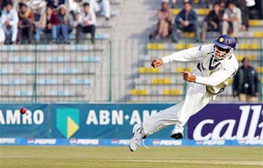 Yuvraj Singh throws the ball as he runs out Pakistani batsman Salman Butt during the first day of the first Test between Pakistan and India at the Gaddafi Cricket Stadium in Lahore