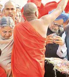 Prime Minister Manmohan Singh and his wife Gursharan Kaur are welcomed by a Buddhist monk as they arrive at Teen Murti House in New Delhi to meet Republic Day performers from different states on Saturday.