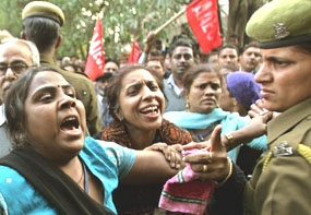 Employees of the Airports Authority of India scuffle with a policewoman during a protest in New Delhi on Tuesday.