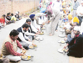 Devotees at a langar organised on Ravidas Jayanti in Ludhiana on Monday