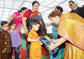 Ms Jean Rodrigues, wife of UT Administrator, hands over bags to children from Bapu Dham Colony at the inauguration of an evening school at Sacred Heart Senior Secondary School, Sector 26, Chandigarh, on Thursday.