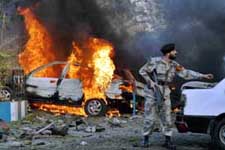 A Pakistani soldier tries to push a car to remove it from a hotel parking lot after a bomb exploded outside the Marriott hotel near the American consulate in Karachi on Thursday