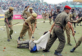 Police personnel arrest a cricket fan who was involved in stone-throwing after the fifth one-day cricket match between India and England was called off due to bad weather in Guwahati on Sunday
